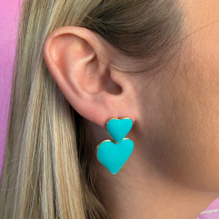 Boucles d’oreilles acier double coeur bleu sur une femme